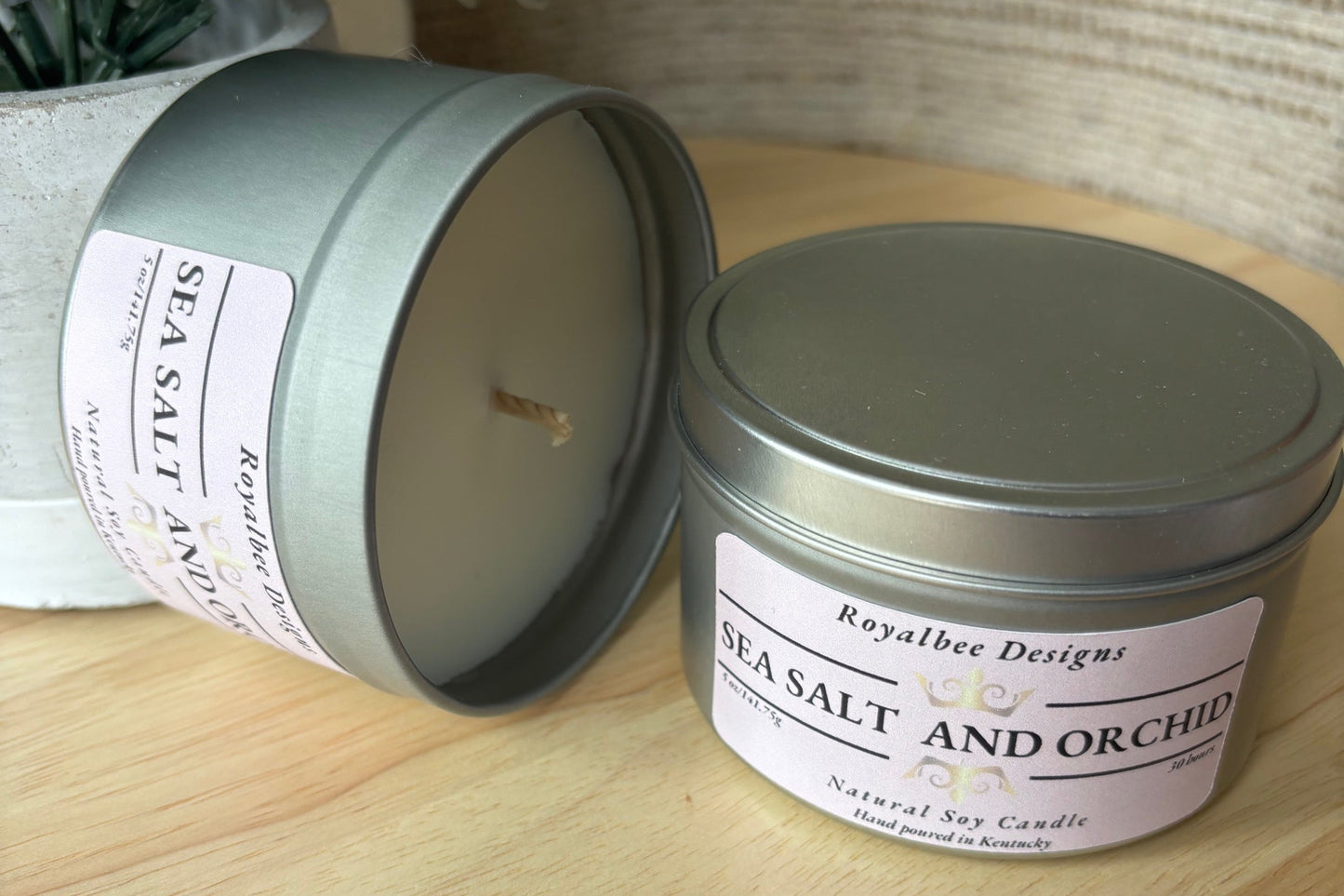 Soy candle in a tin with 'Sea Salt and Orchid' fragrance label
