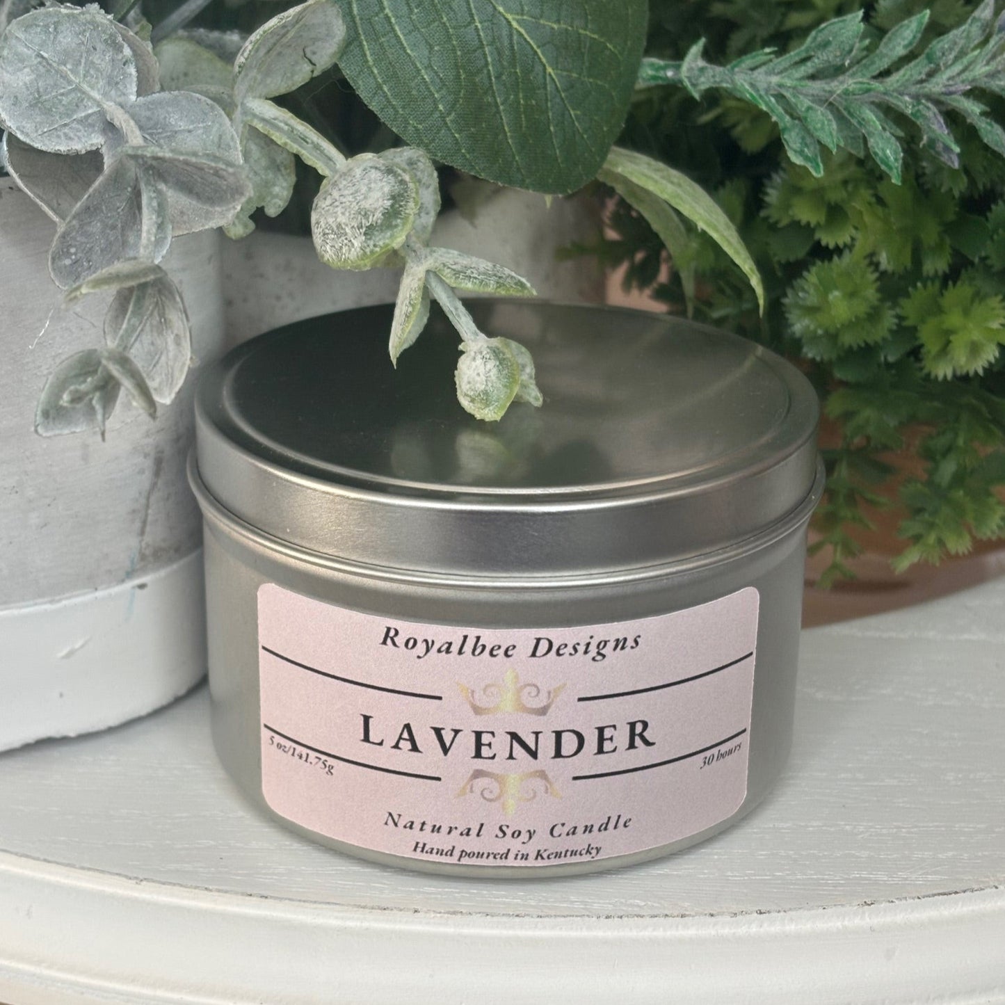 Lavender candle in a metal tin with a pink label sold by Royalbee Deisigns.