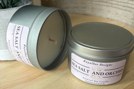 Soy candle in a tin with 'Sea Salt and Orchid' fragrance label 